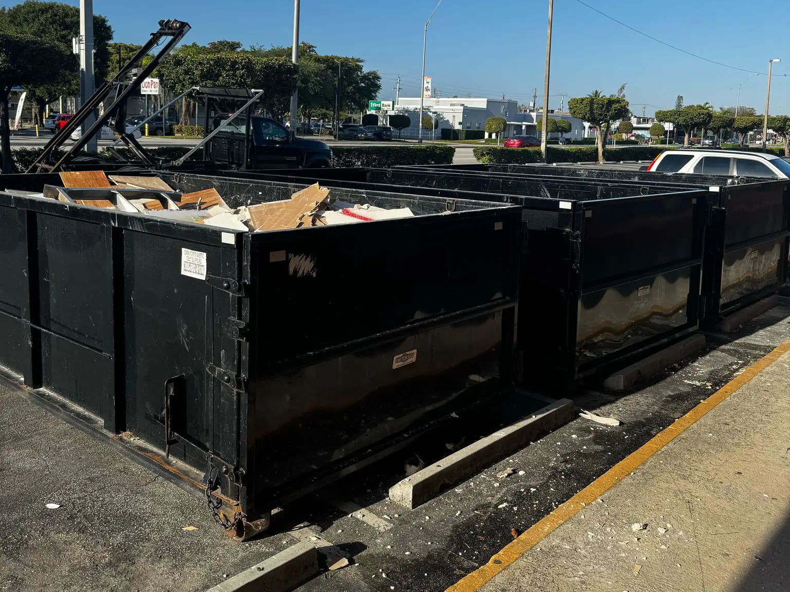 Roll-off dumpster on a Miami roofing tear-off job site